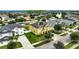 Aerial view of a yellow two-story house with solar panels, and a neighborhood at 10820 Carloway Hills Drive, Wimauma, FL 33598