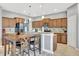 Modern kitchen with wood cabinets, granite countertops and breakfast bar at 10820 Carloway Hills Drive, Wimauma, FL 33598