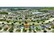 Aerial view of a house in a neighborhood with many other homes and a lake at 10820 Carloway Hills Drive, Wimauma, FL 33598
