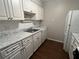 White kitchen cabinets, tile backsplash, and wood-look floors at 4315 Aegean Dr # 126C, Tampa, FL 33611