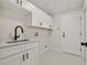 Laundry room with white cabinets and a modern sink at 1233 Acappella Ln, Apollo Beach, FL 33572