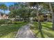 Community grounds with a stone path, grass, and mature trees at 3730 42Nd S Way # G, St Petersburg, FL 33711