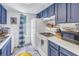 Well-equipped kitchen with blue cabinets and white appliances at 3730 42Nd S Way # G, St Petersburg, FL 33711