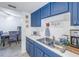 Bright kitchen boasts blue cabinetry, stainless steel sink, and views into dining area at 3730 42Nd S Way # G, St Petersburg, FL 33711