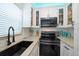 Well-equipped kitchen with white cabinets and stylish backsplash at 724 Gulf Blvd # A & B, Indian Rocks Beach, FL 33785
