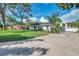 White brick home with gray roof, landscaped lawn, and long driveway at 1164 Murok S Way, St Petersburg, FL 33705