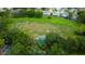 Aerial view shows green space, playground, and tennis courts surrounded by houses with pools, offering many activity options at 11426 Glenmont Dr, Tampa, FL 33635