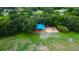 Aerial view of a playground area with swings and covered play equipment with mature trees and green space around it at 11426 Glenmont Dr, Tampa, FL 33635