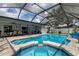 Inviting pool and spa under a screened enclosure, surrounded by patio area, offering a refreshing outdoor oasis at 11426 Glenmont Dr, Tampa, FL 33635