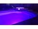 Night view of a luxurious pool and spa with colorful LED lighting creating a serene backyard ambiance at 11426 Glenmont Dr, Tampa, FL 33635