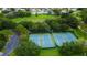 Aerial view of a parking lot next to two tennis courts surrounded by lush green trees in a beautiful neighborhood at 11426 Glenmont Dr, Tampa, FL 33635