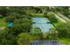 Aerial view showcases neighborhood tennis courts, well-maintained and surrounded by lush trees for a beautiful playing environment at 11426 Glenmont Dr, Tampa, FL 33635