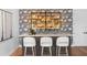 A stylish wet bar area features a marble countertop, decorative backsplash, and seating for three at 4536 W Swann Ave, Tampa, FL 33629