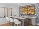 Stylish wet bar area features a marble countertop, decorative backsplash, and seating for three at 4536 W Swann Ave, Tampa, FL 33629