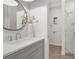 Bathroom featuring a gray vanity, round mirror, and a glass-enclosed shower with stylish tile at 4536 W Swann Ave, Tampa, FL 33629