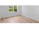 A cozy bedroom features hardwood floors and a large window that offers a view of lush greenery at 4536 W Swann Ave, Tampa, FL 33629