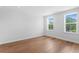 A bright bedroom boasts hardwood floors, white walls, and natural light from two windows at 4536 W Swann Ave, Tampa, FL 33629