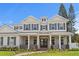 Elegant home showcasing white columns, a covered porch, and manicured landscaping under a blue sky at 4536 W Swann Ave, Tampa, FL 33629