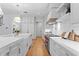 Modern kitchen with white cabinetry, stainless steel appliances, and a large center island with a farmhouse sink at 4536 W Swann Ave, Tampa, FL 33629
