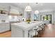Spacious kitchen with a large island with bar seating, modern light fixtures, and white countertops and cabinets at 4536 W Swann Ave, Tampa, FL 33629
