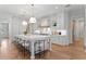 Open kitchen with a large island, bar stool seating, modern lighting, and white custom cabinetry and countertops at 4536 W Swann Ave, Tampa, FL 33629