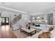 Open-concept living area with hardwood floors, staircase, modern furniture, and a view into the kitchen at 4536 W Swann Ave, Tampa, FL 33629