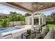 Covered patio with stylish outdoor furniture, fan, and a view of the pool and lush landscaping creating a relaxing retreat at 4536 W Swann Ave, Tampa, FL 33629