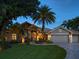 Two-story house exterior with a beautifully landscaped front yard at night at 1299 Coverstone Ct, Oldsmar, FL 34677