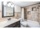 Bathroom with dark vanity, tile shower, and neutral tile at 205 Se Monroe N Cir, St Petersburg, FL 33703