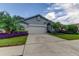 One story home with attached garage, landscaping, and palm trees at 11426 Glenmont Dr, Tampa, FL 33635