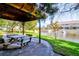 Relaxing gazebo with a picnic table overlooking a pond at 11126 Kapok Grand Cir, Madeira Beach, FL 33708