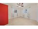 Well-lit bedroom with dual windows, ceiling fan and red armoire at 2452 Chaucer St, Clearwater, FL 33765