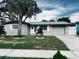 Ranch-style home with gray exterior, landscaping and driveway at 1632 Dander Dr, Holiday, FL 34690