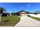 Tan one-story house with a two-car garage and well-maintained lawn at 1728 W Lagoon Cir, Clearwater, FL 33765