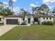 Modern single-story home with dark brown roof, light-colored walls, and a two-car garage at 3616 Bellefonte Ave, North Port, FL 34286