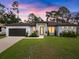 Modern single-story home with dark brown roof, light-colored walls, and a two-car garage at 3616 Bellefonte Ave, North Port, FL 34286