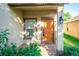 Orange front door with a small covered porch and landscaping at 14211 Edinburgh Moor Dr, Wimauma, FL 33598