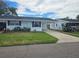 Front view of a single-story home with a landscaped lawn and driveway at 5080 Park Lake N Dr # 110, Pinellas Park, FL 33782