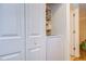 White stacked washer and dryer in a small laundry room with extra storage at 10100 Sailwinds N Blvd # 205, Largo, FL 33773