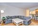 Cozy living room with a sectional sofa and a view to the kitchen at 10100 Sailwinds N Blvd # 205, Largo, FL 33773