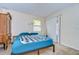 Bedroom with a teal bedspread, dresser, and sliding door at 10100 Sailwinds N Blvd # 205, Largo, FL 33773