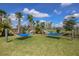 Peaceful lawn with two blue hammocks for relaxing in the sun at 6378 Camino Dr, Apollo Beach, FL 33572