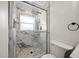 Modern bathroom with glass shower enclosure and marble tile, plus a toilet and ring towel holder at 6750 W Flamingo S Way, St Petersburg, FL 33707