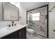 Bathroom featuring glass shower enclosure with marble tile, modern lighting above the mirror, and dark vanity at 6750 W Flamingo S Way, St Petersburg, FL 33707