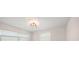 Bedroom featuring a modern ceiling light fixture, two windows with blinds, and white walls at 6750 W Flamingo S Way, St Petersburg, FL 33707