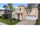 Two-story house with a peach-colored exterior, white garage door, and lush landscaping at 10713 Cape Hatteras Dr, Tampa, FL 33615