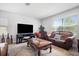 Living room with brown leather couches, a large TV, and a coffee table at 35716 Hillbrook Ave, Zephyrhills, FL 33541