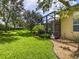 Expansive backyard featuring lush landscaping and a screened patio at 5014 Ruby Flats Dr, Wimauma, FL 33598