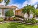 Landscaped front yard with palm trees and flowering bushes at 5014 Ruby Flats Dr, Wimauma, FL 33598