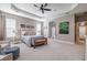 Bright main bedroom with carpeted floor, ceiling fan, and large windows at 5014 Ruby Flats Dr, Wimauma, FL 33598